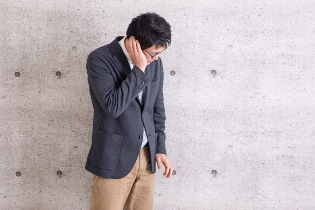 耳を抑える男性