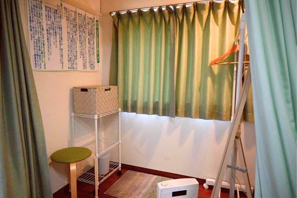 更衣室の様子です。お荷物を置くかごやキャスター、お洋服をかけるハンガーラック、椅子、姿見、足元にはマットがあります。